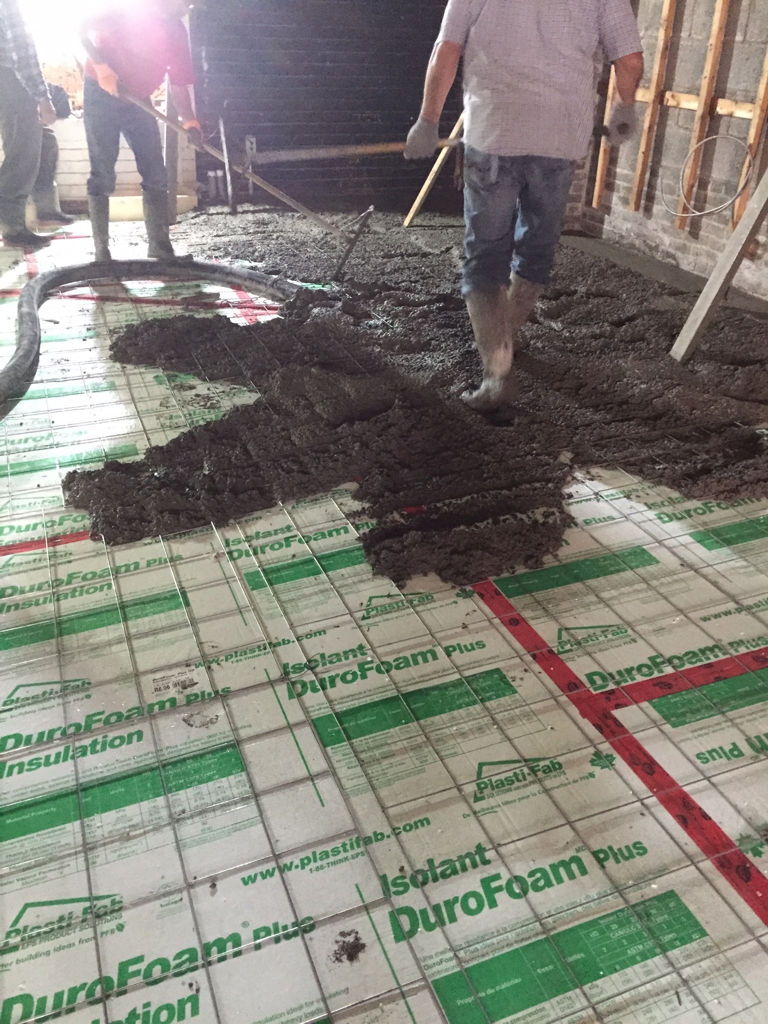 A group of men are working on a concrete floor.