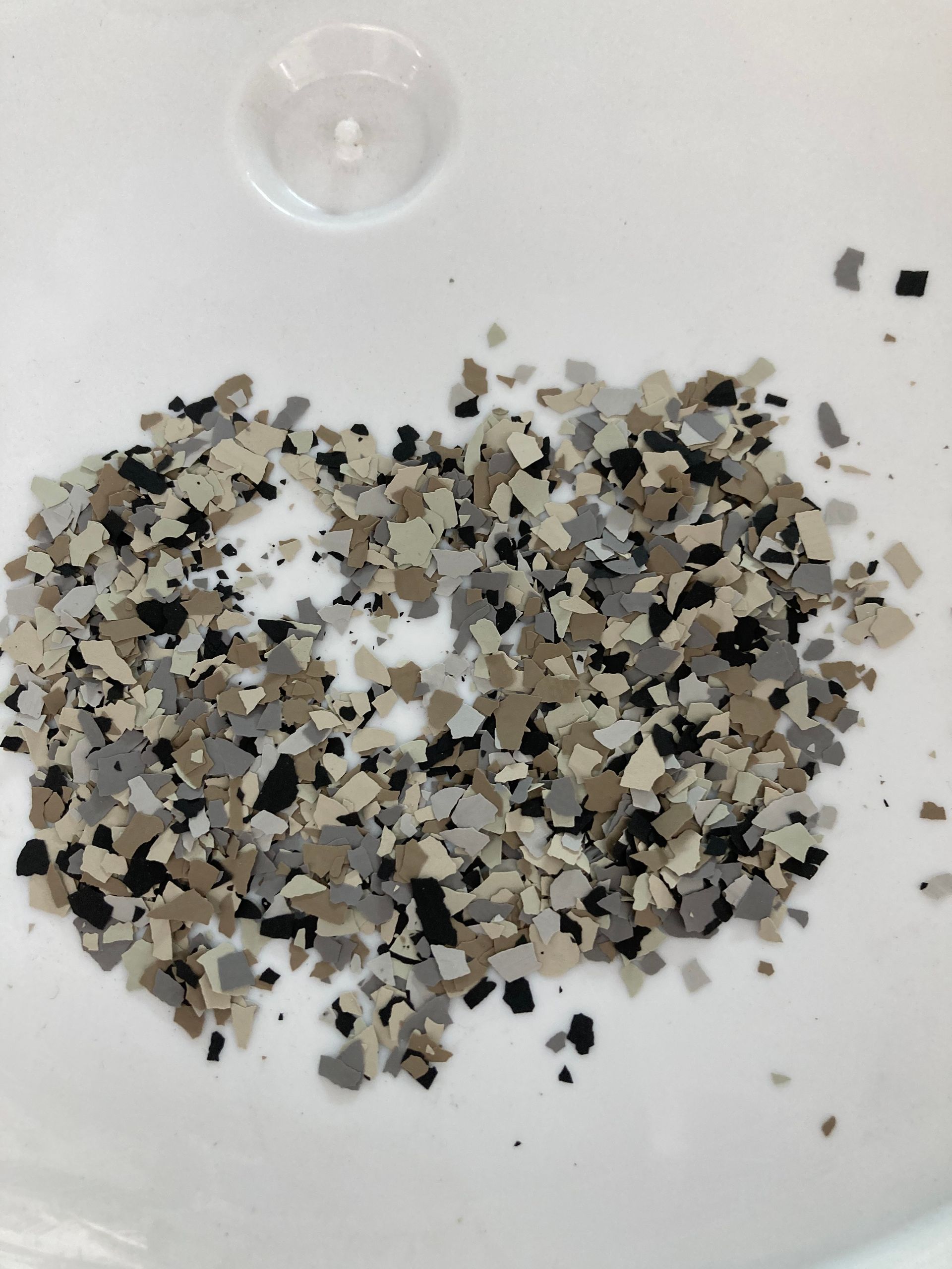 A pile of brown black and white chips on a white surface