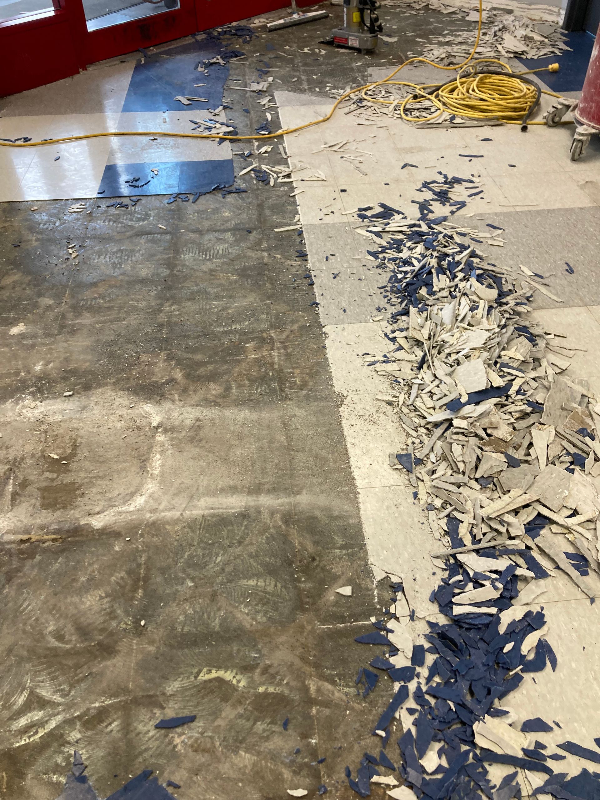 A dirty floor with a lot of pieces of paper on it.