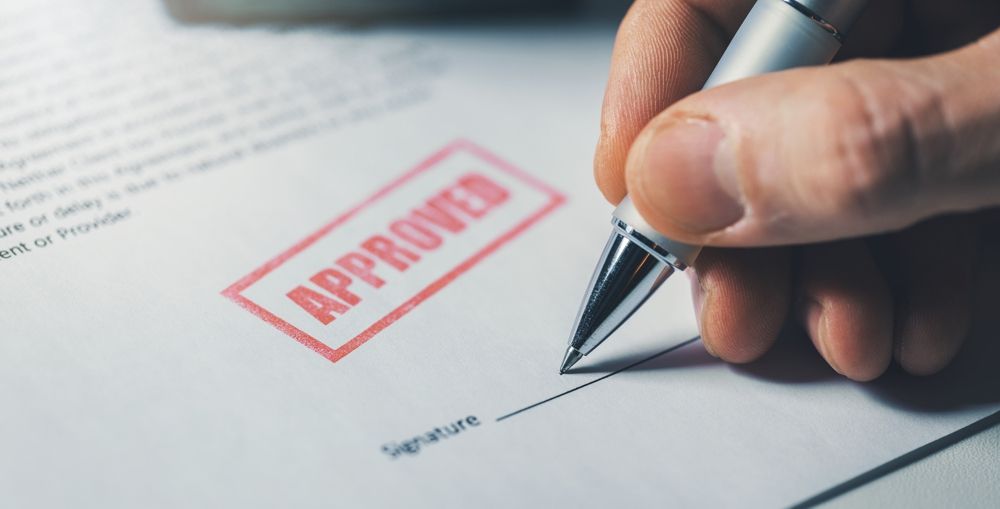 Hand signing a document stamped 