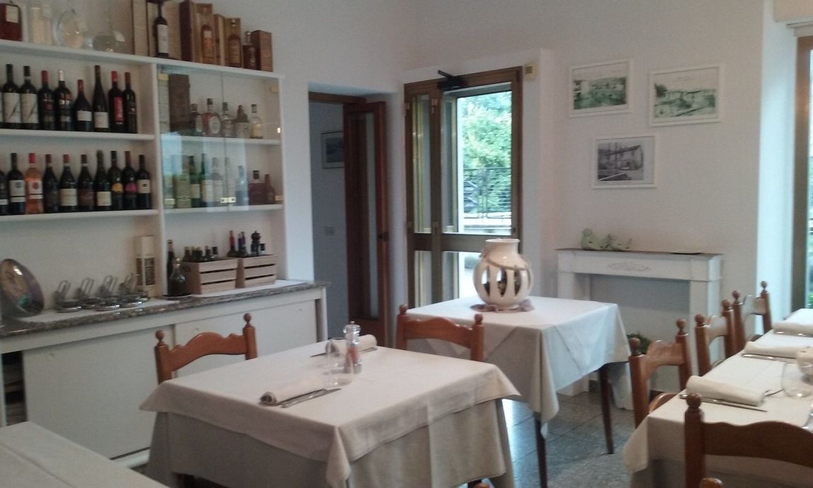 a restaurant with tables and chairs and bottles on shelves