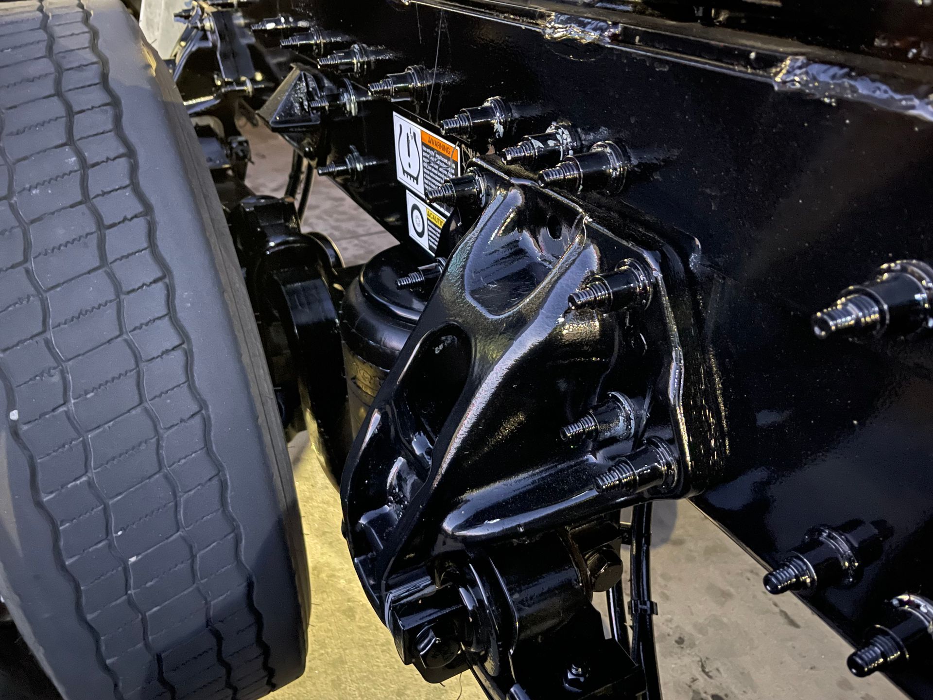 A close up of a black truck with a tire on it.