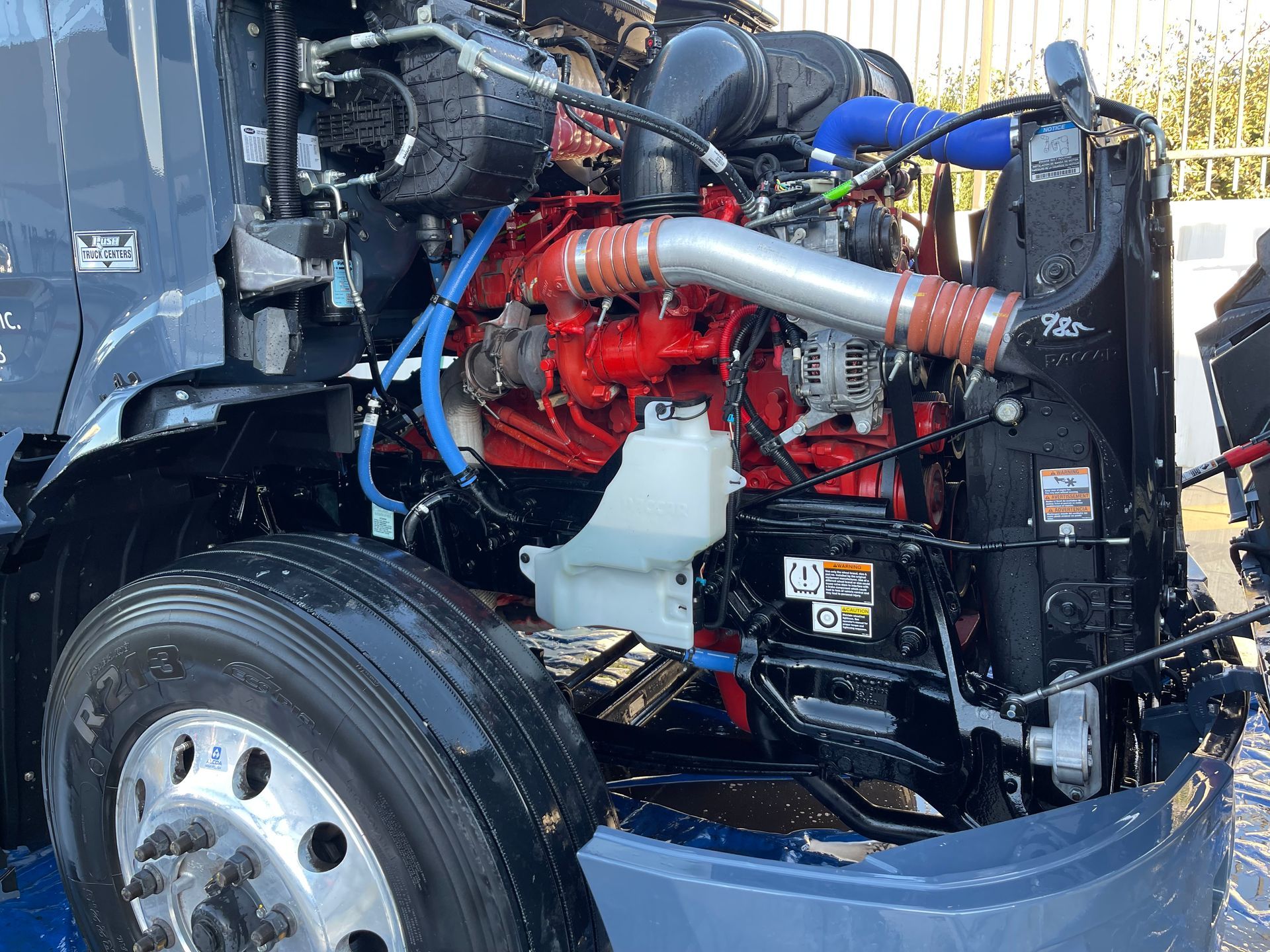 The engine of a semi truck is sitting under the hood.