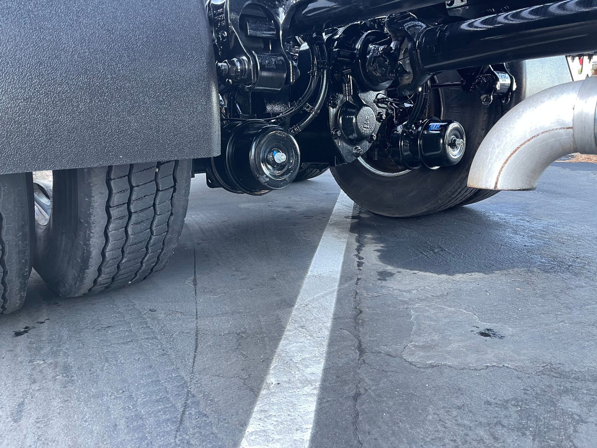 A truck is parked in a parking lot next to a white line.