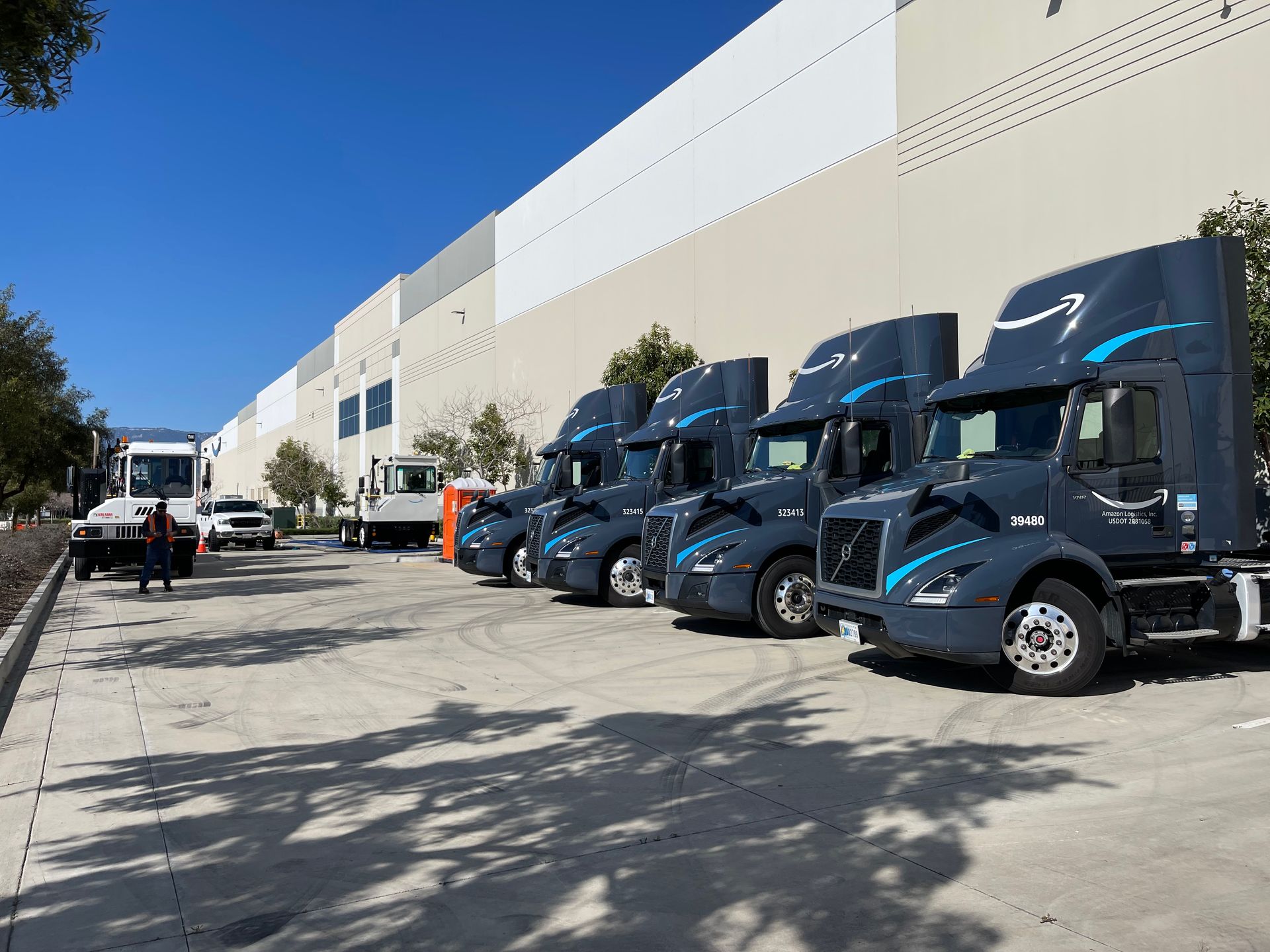 A row of semi trucks parked in front of a building.