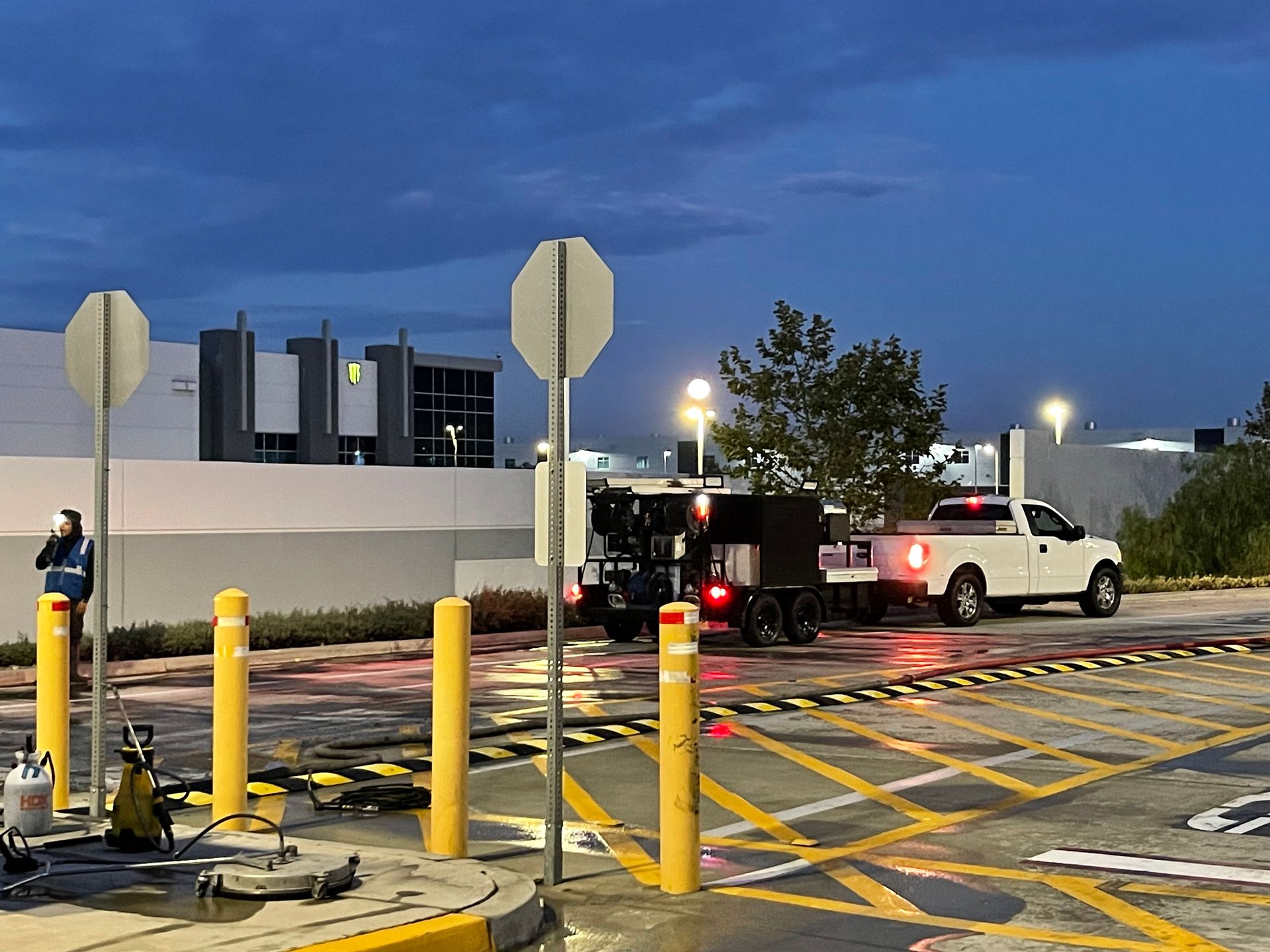A white truck is parked in a parking lot at night.