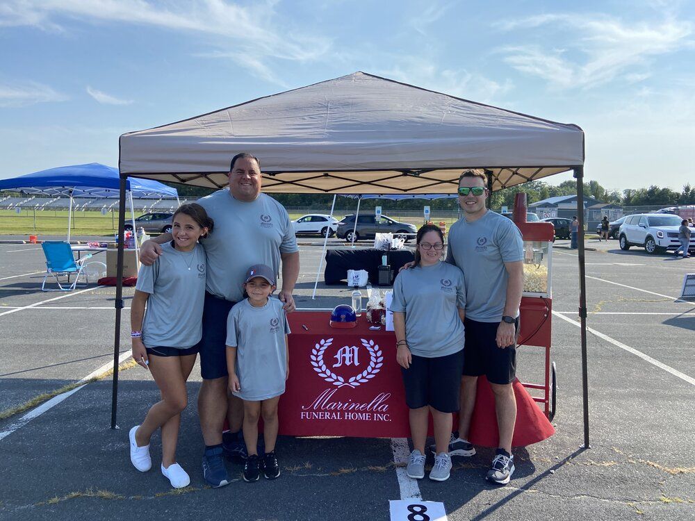 A family is posing for a picture in front of a tent in a parking lot.