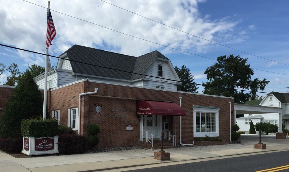 A living room with a couch , chairs , and a clock.