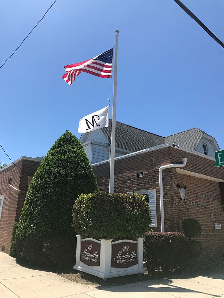 An american flag is flying in front of a brick building.