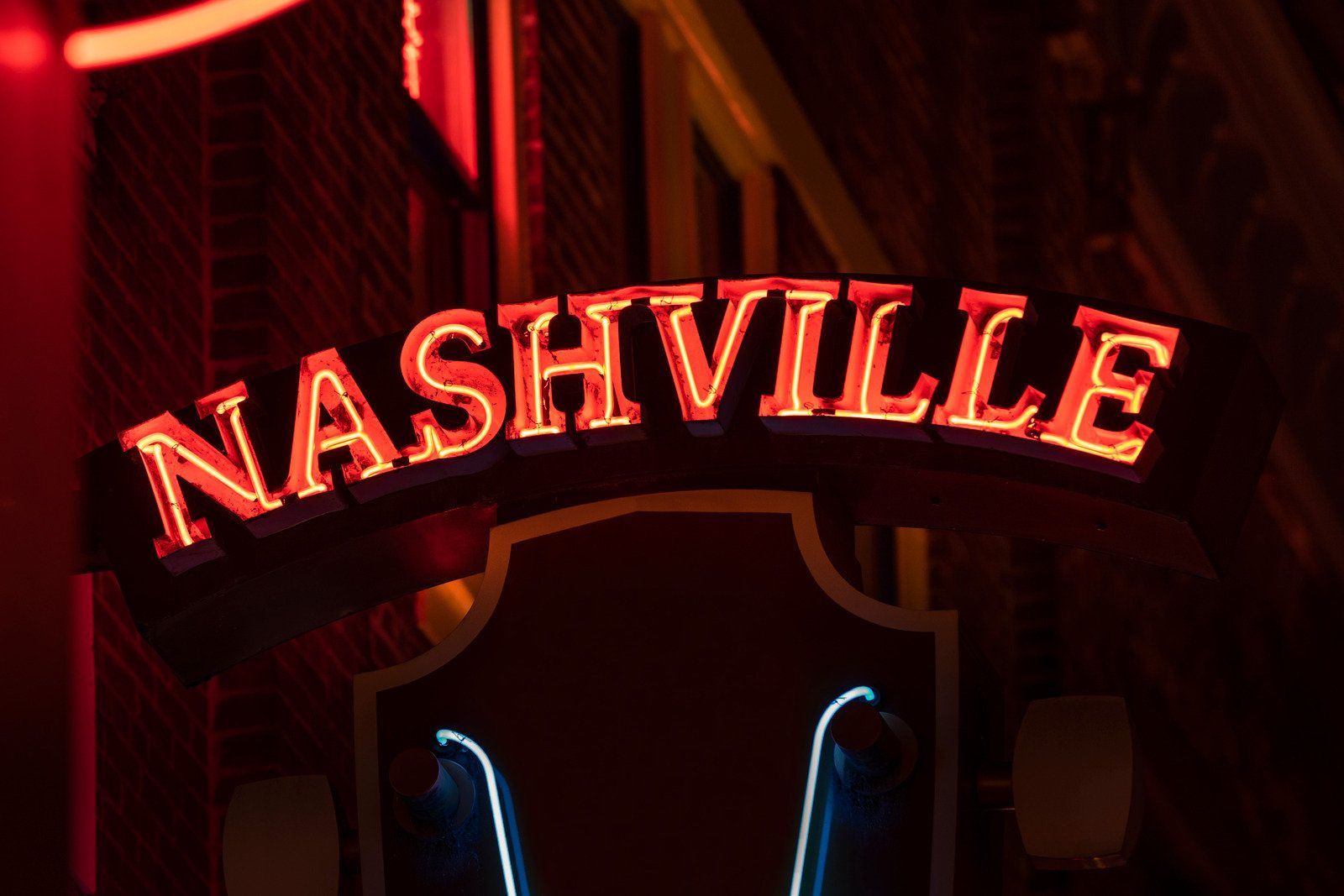 A neon sign for nashville is lit up at night.