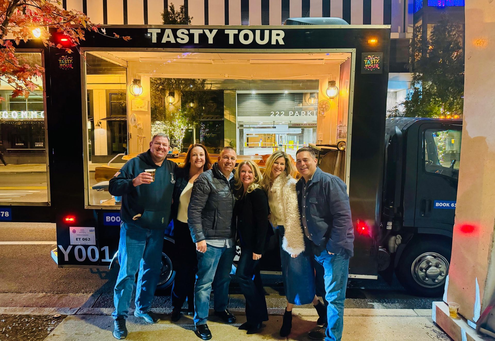 A group of people are posing for a picture in front of a food truck.