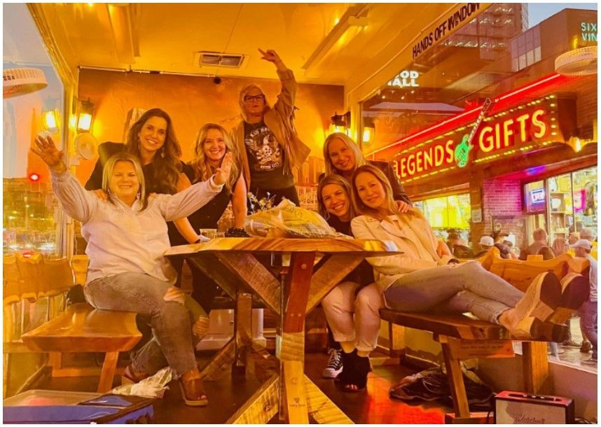 A group of people are sitting around a table in a restaurant.