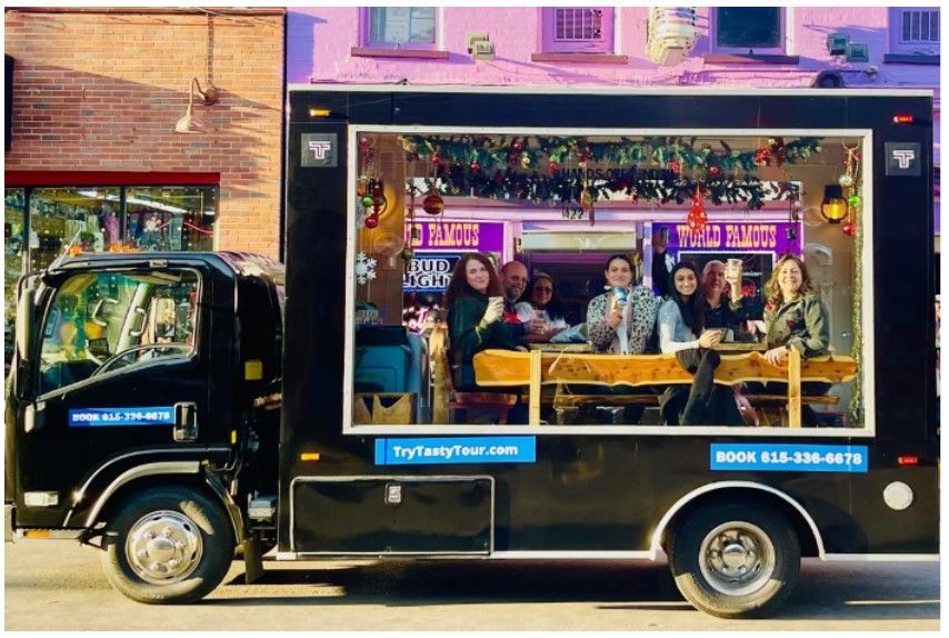 A group of people are sitting at tables in a food truck.