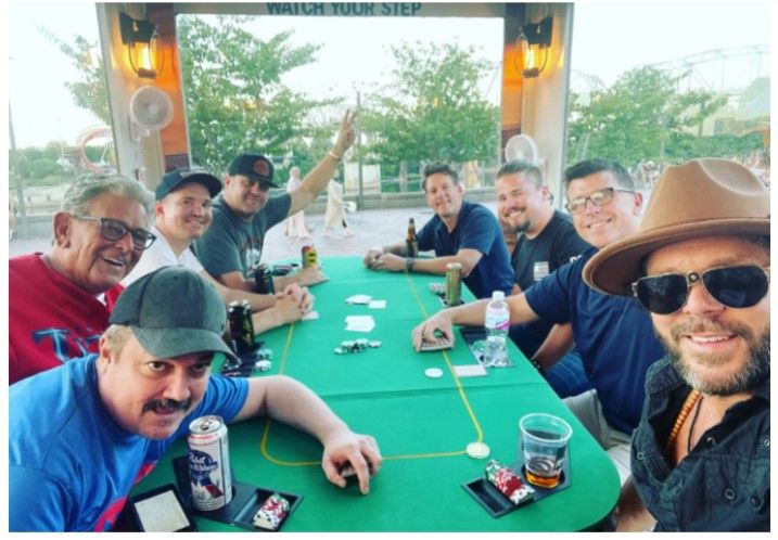 A group of men are sitting around a table playing poker