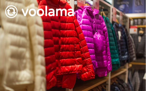 A row of colorful down jackets hanging on a rack in a store.