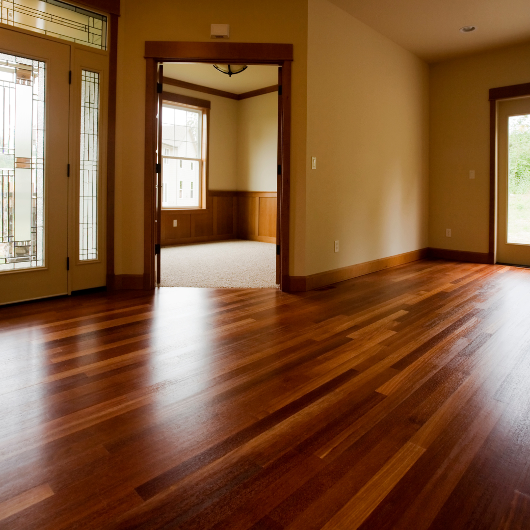 An empty room with hardwood floors and stained glass doors.