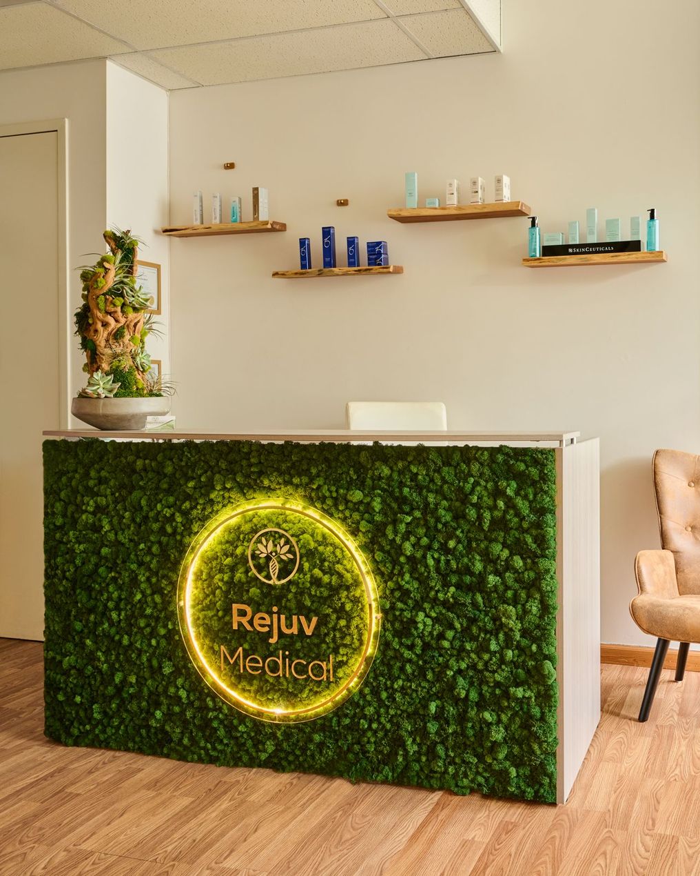 A reception desk in a room with a green wall and a chair.