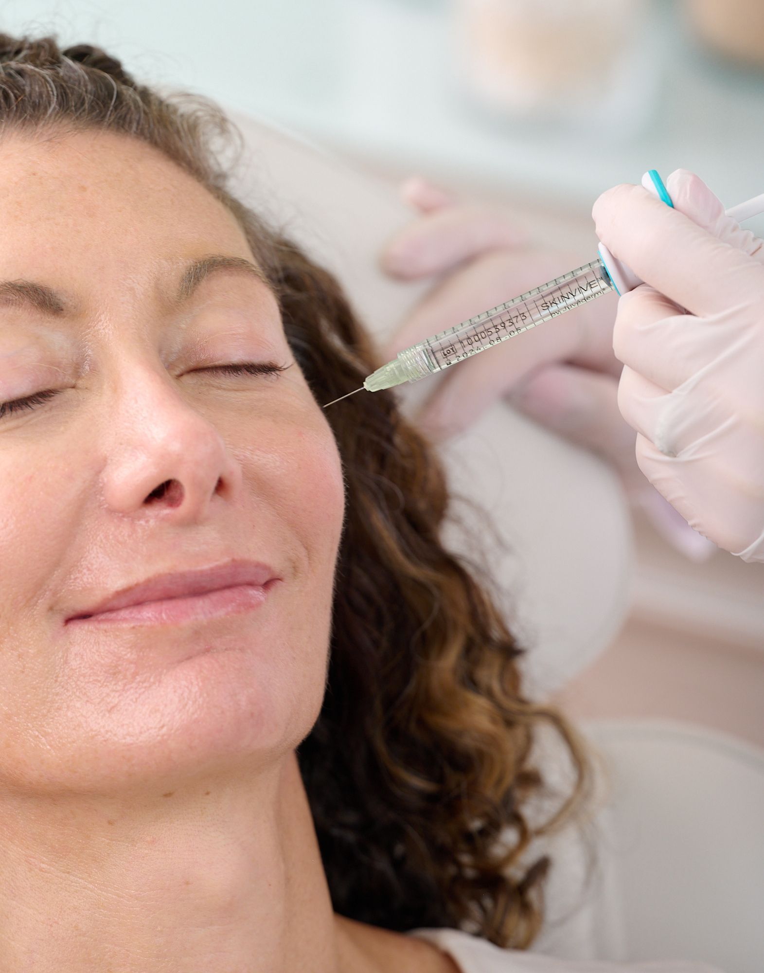 A woman is getting a botox injection in her face.