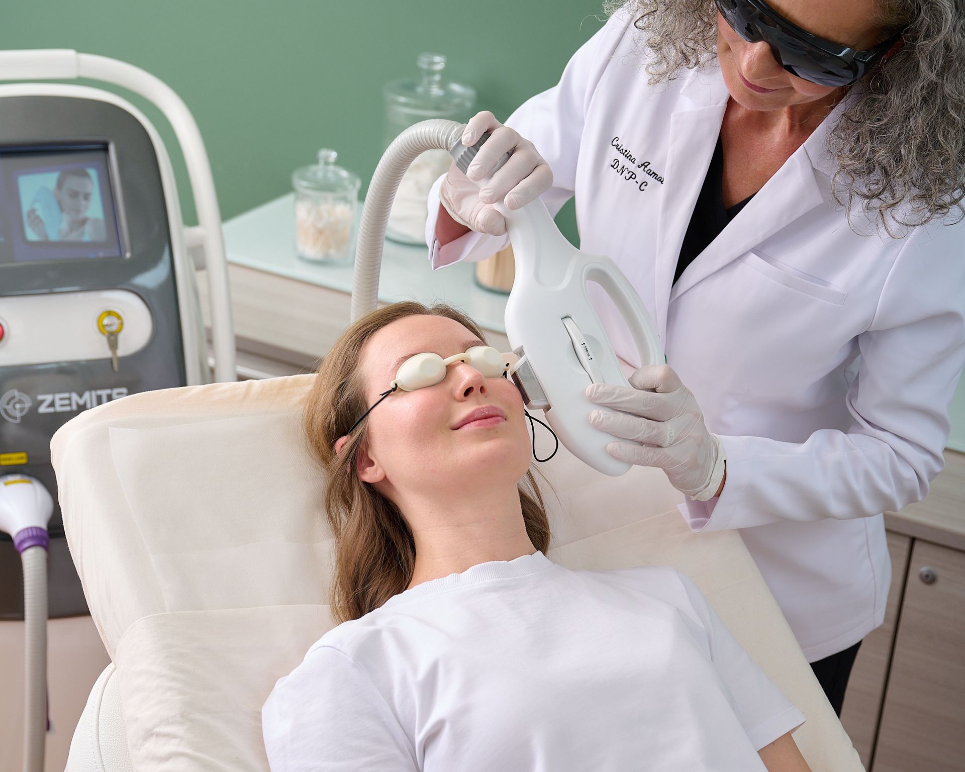 A woman is getting a laser treatment on her face.