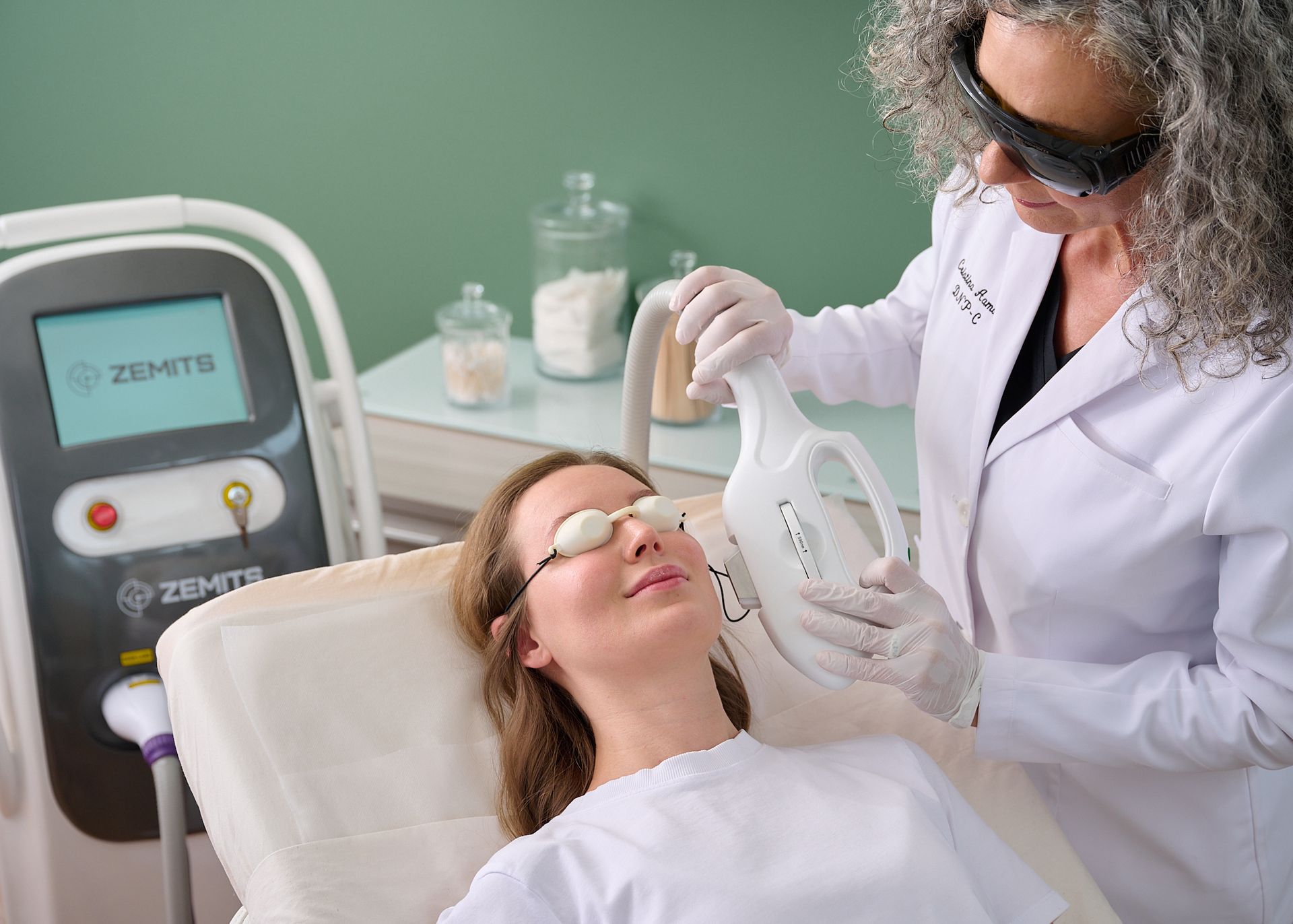 A woman is getting a laser treatment on her face.