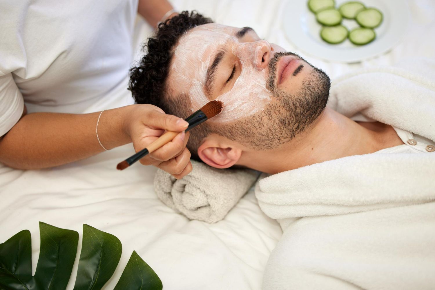 A man is getting a facial treatment at a spa.