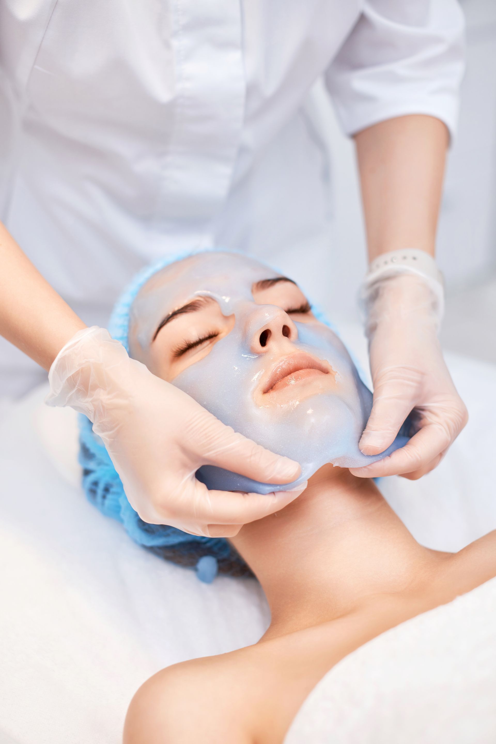 A woman is getting a facial treatment at a beauty salon.