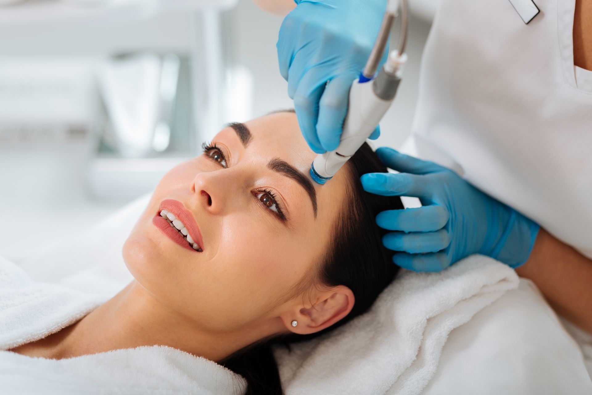 A woman is getting a facial treatment at a beauty salon.