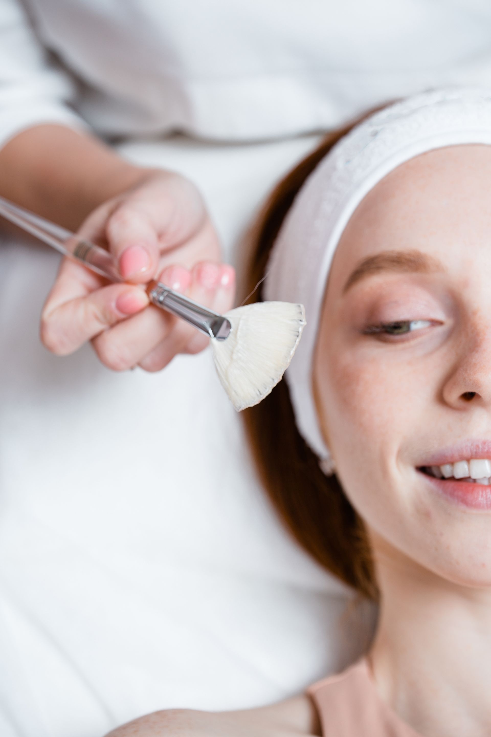 A woman is getting a facial treatment at a beauty salon.