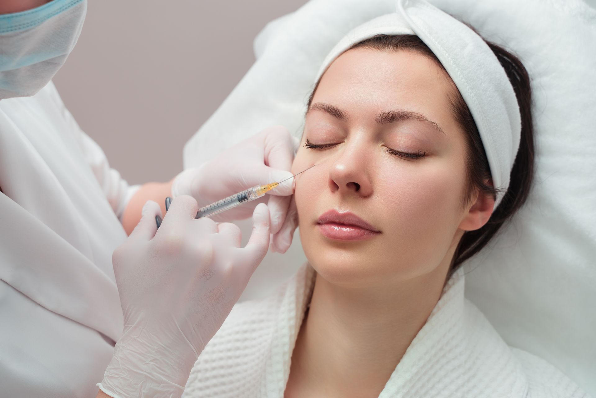 A woman is getting a botox injection in her face.