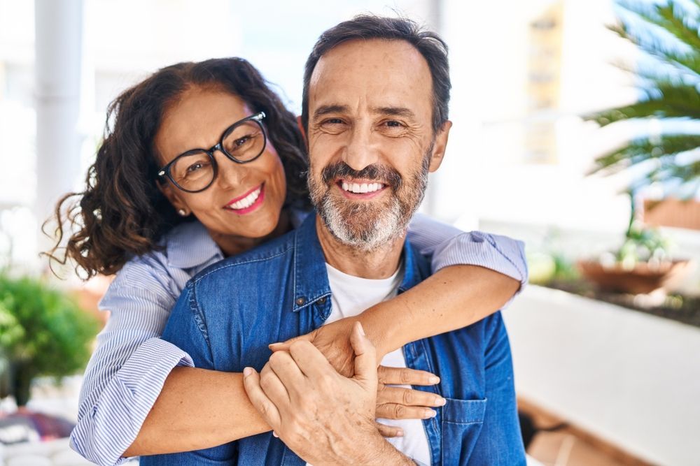 A woman is hugging a man on his back.