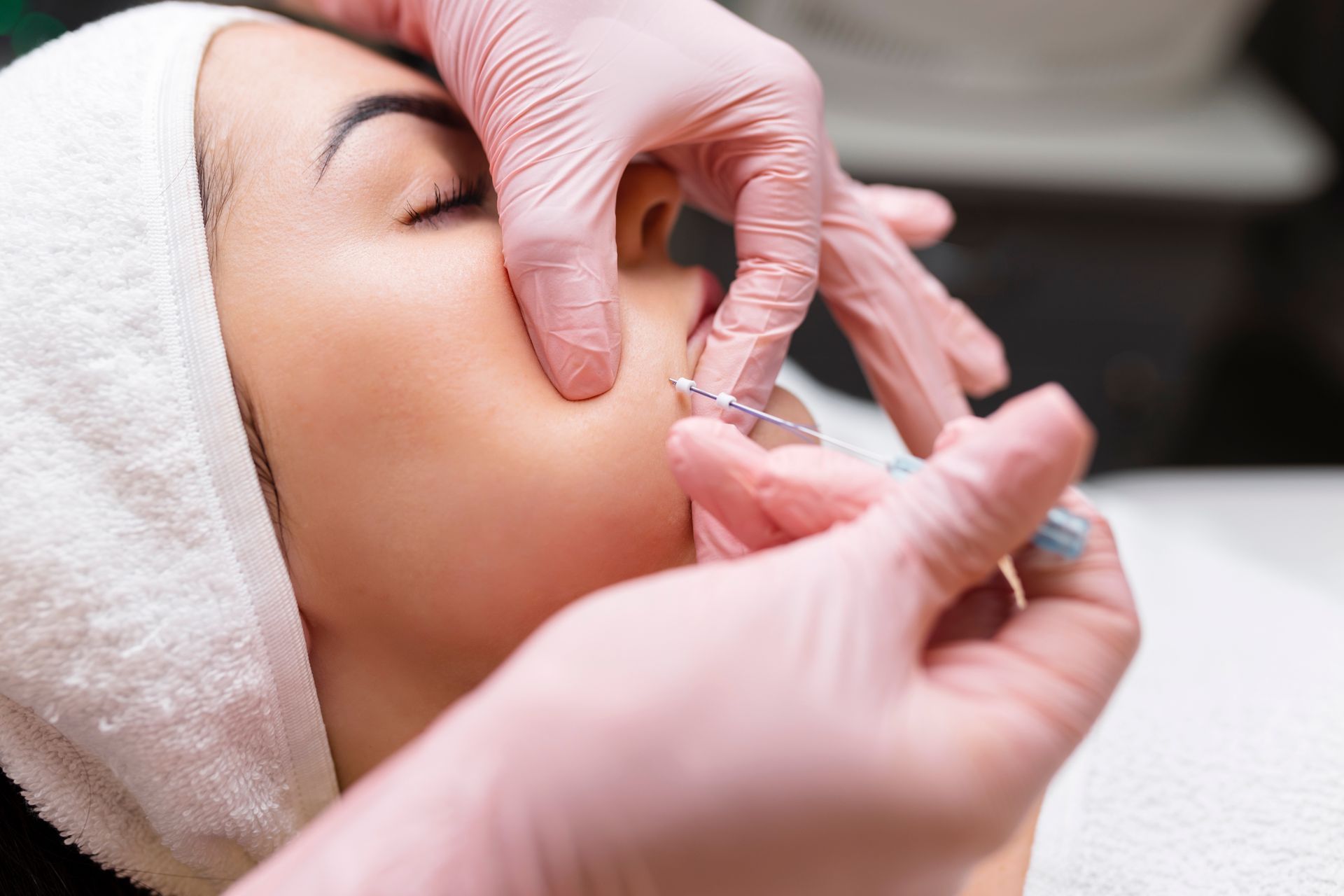 A woman is getting a botox injection in her face.