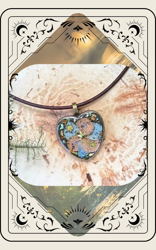 Heart-shaped pendant with blue and gold floral design on a brown leather cord against a light wood background.