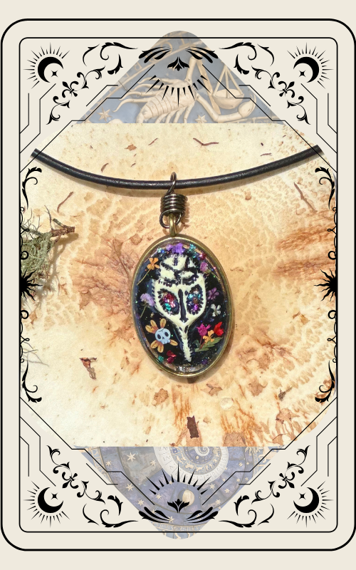 Oval pendant with a colorful design on black cord, set on a textured gold background, framed with decorative lines.