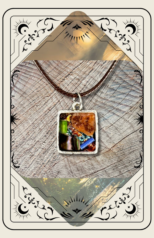 A square pendant featuring colorful, textured fragments set in resin, hanging on a cord against a wood background.
