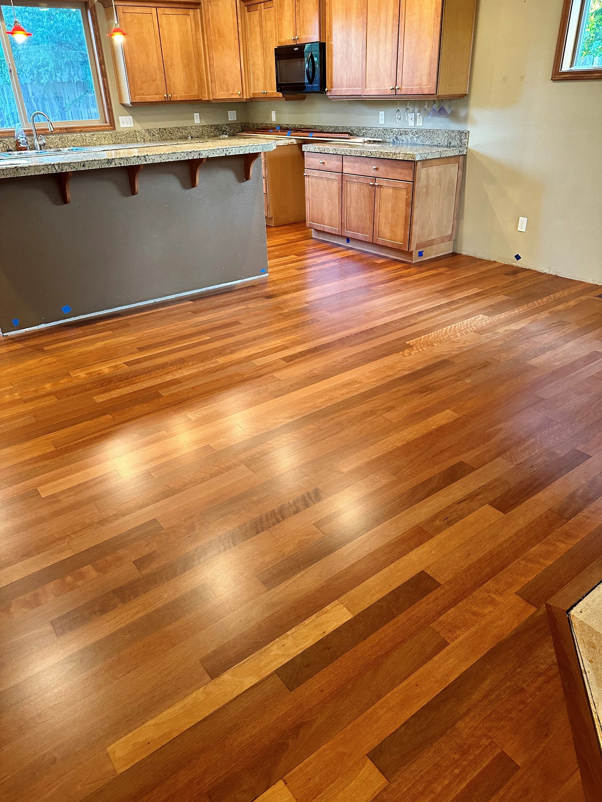 A kitchen with wooden cabinets and a wooden floor