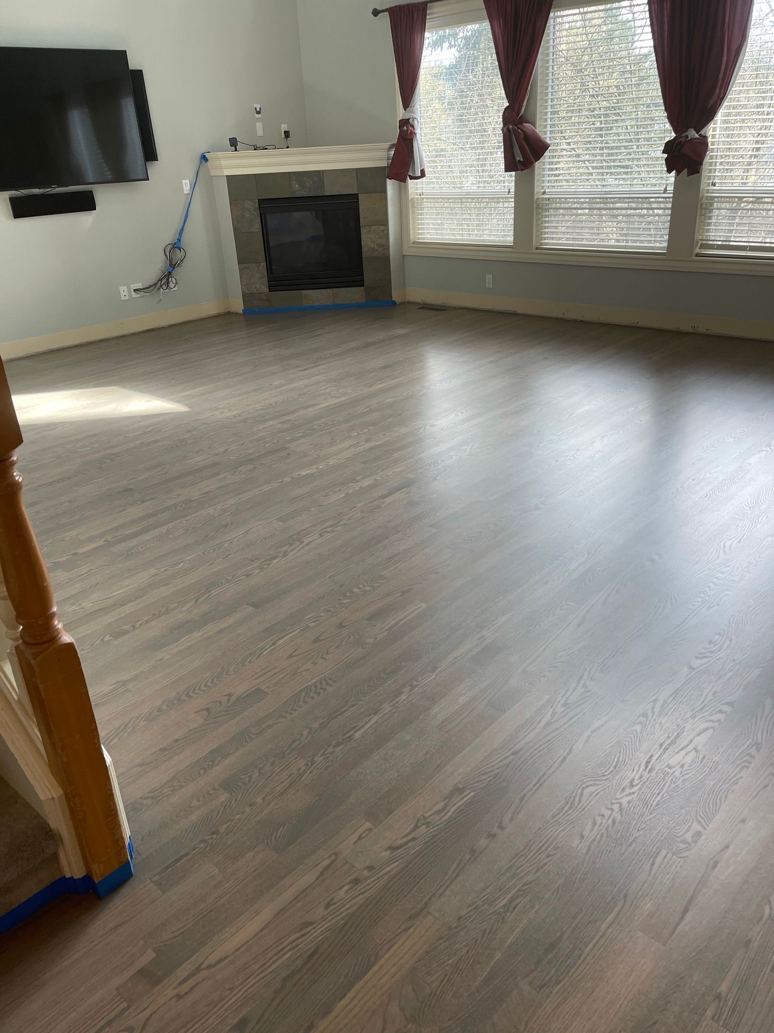 A living room with hardwood floors and a fireplace.