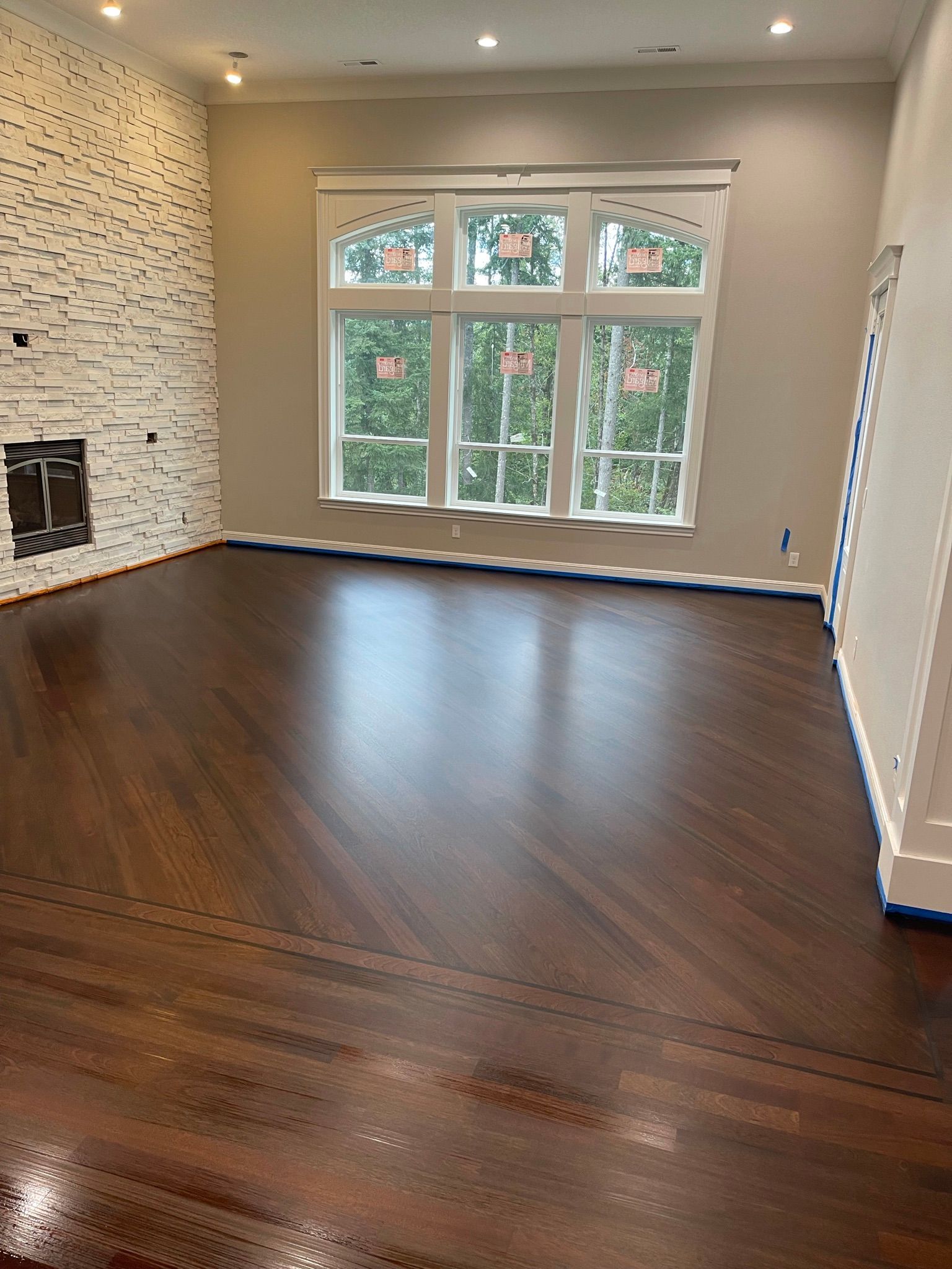 An empty living room with hardwood floors and a fireplace.