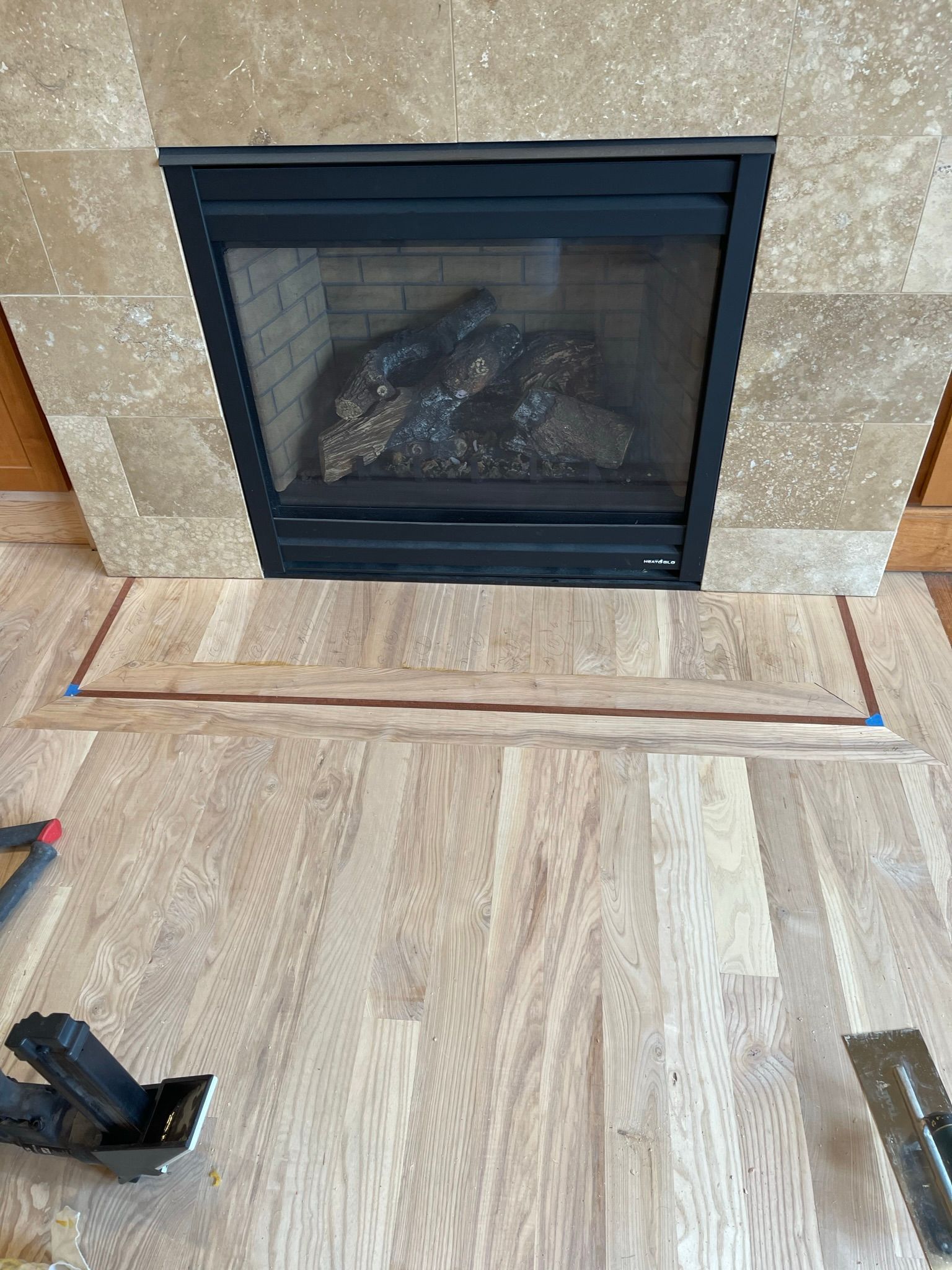 A fireplace with a wooden floor in front of it.