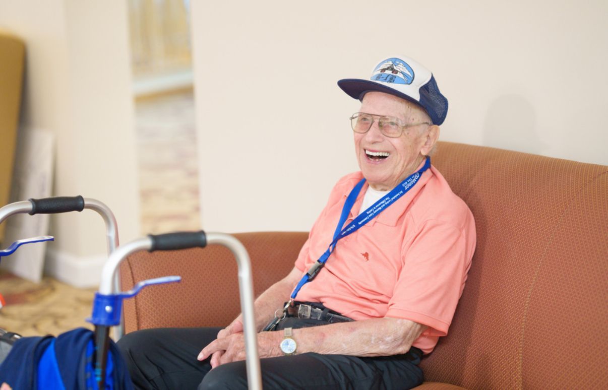 An elderly woman in a wheelchair is being comforted by a nurse.