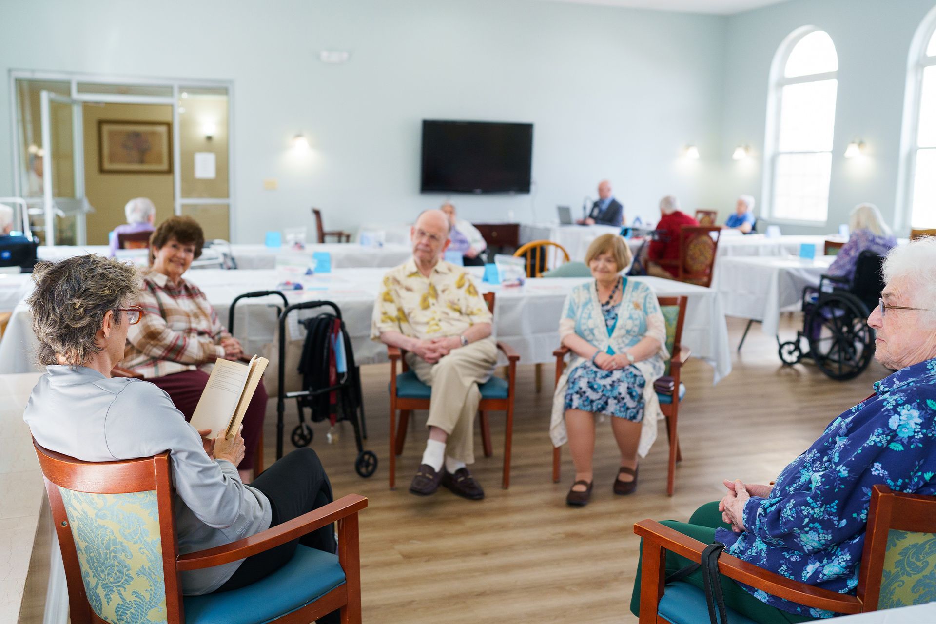 A group of elderly people are sitting in chairs in a room.