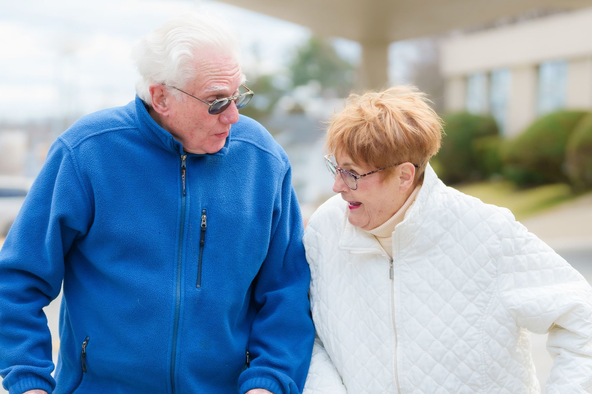 A nurse and a woman are dancing in front of an elevator.