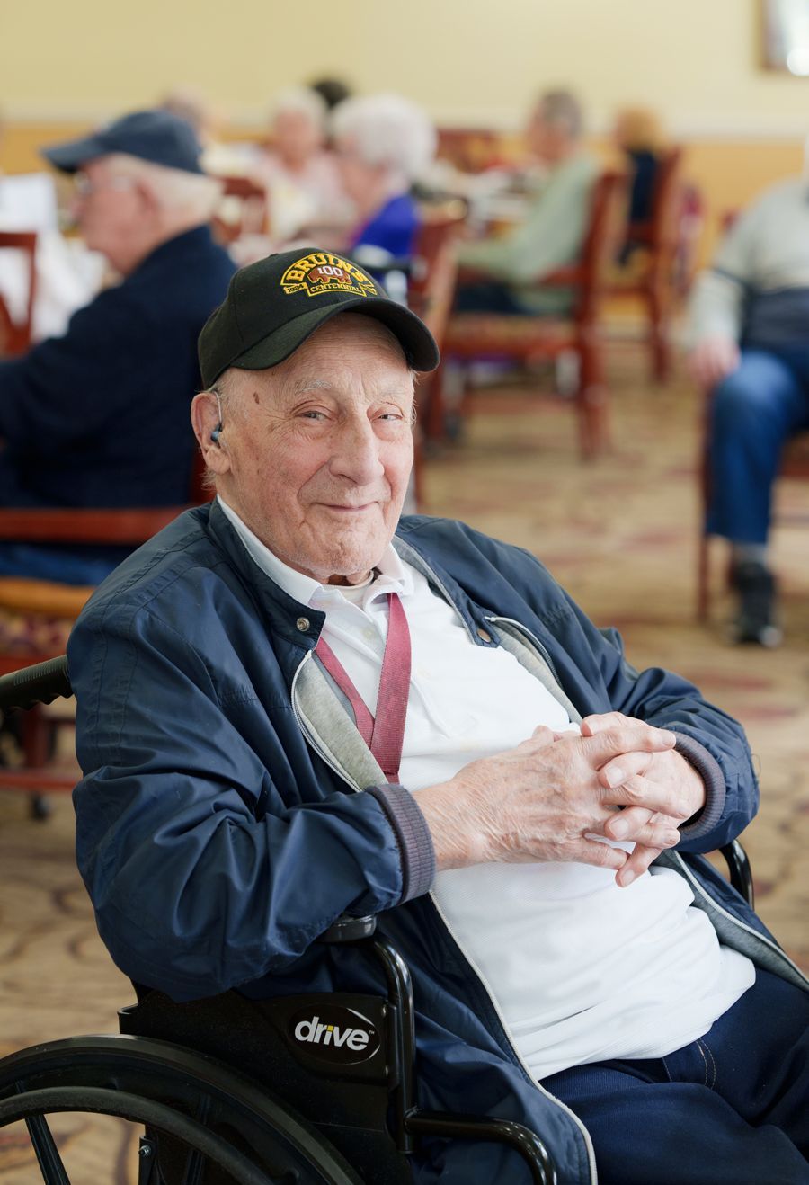 A man in a wheelchair is sitting in a room with other people.