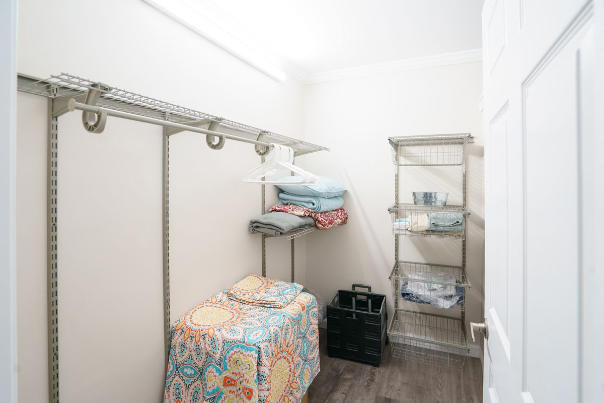 A closet with a bed , shelves , and a door.
