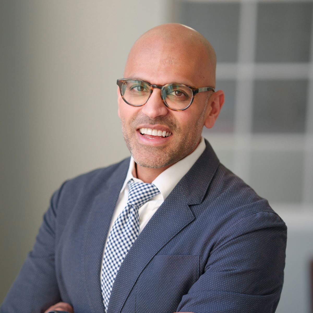 A bald man wearing glasses and a suit and tie
