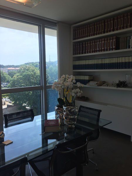 libreria con un tavolo di cristallo e orchidee sul tavolo in uno studio legale