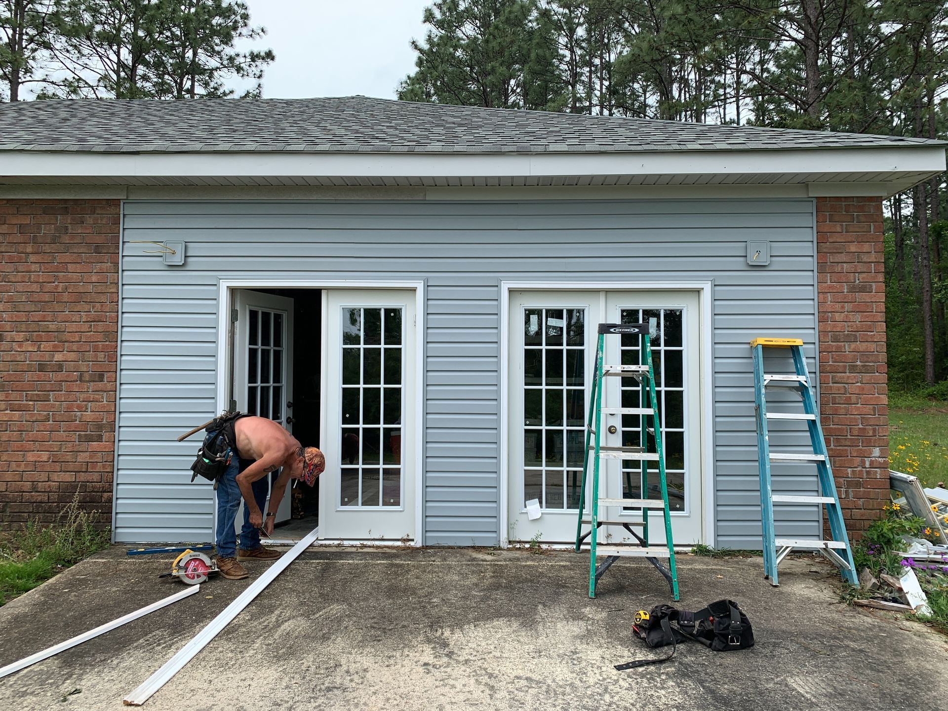 A man is working on the side of a house.