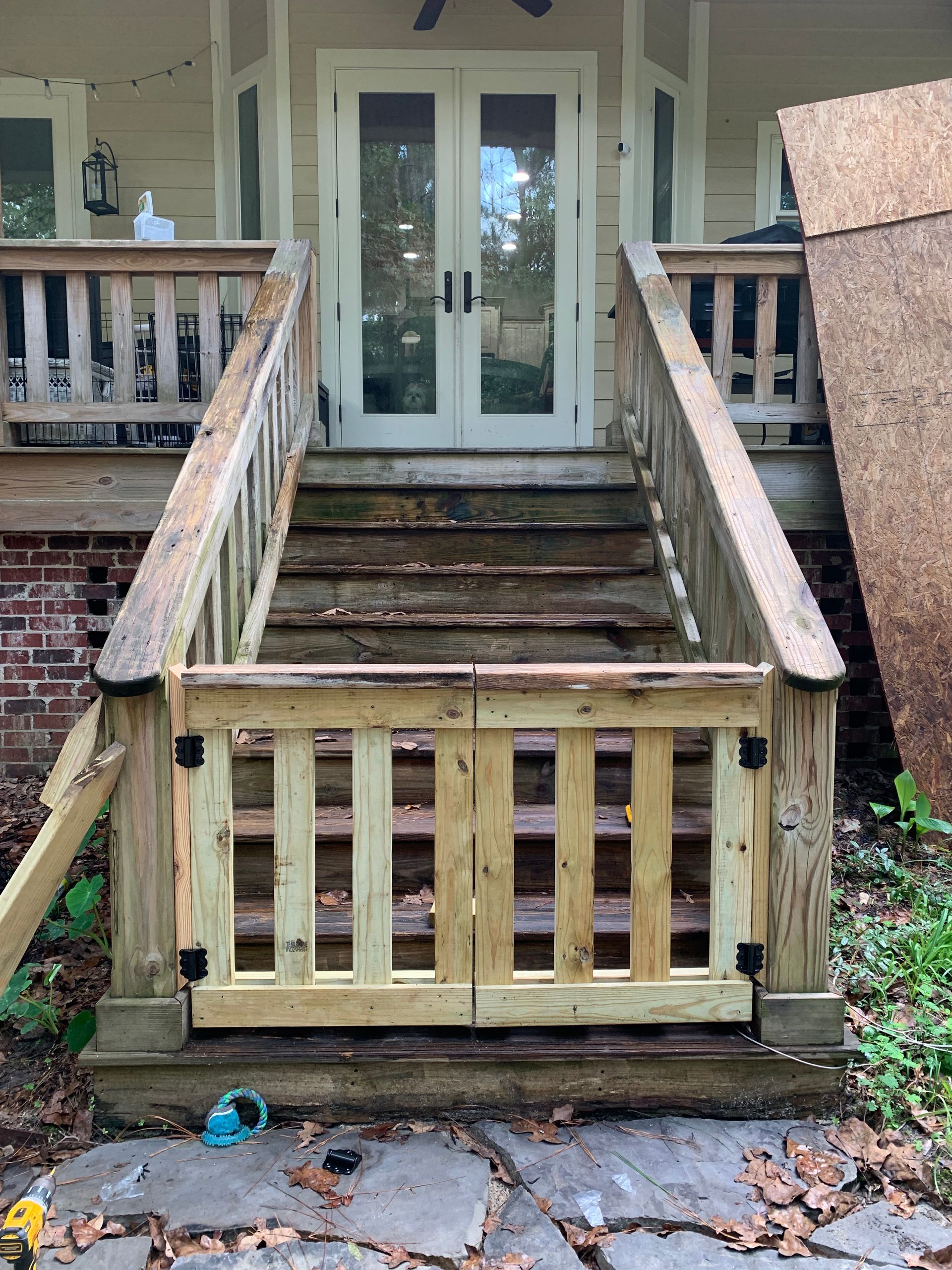 A wooden gate is on the steps of a house