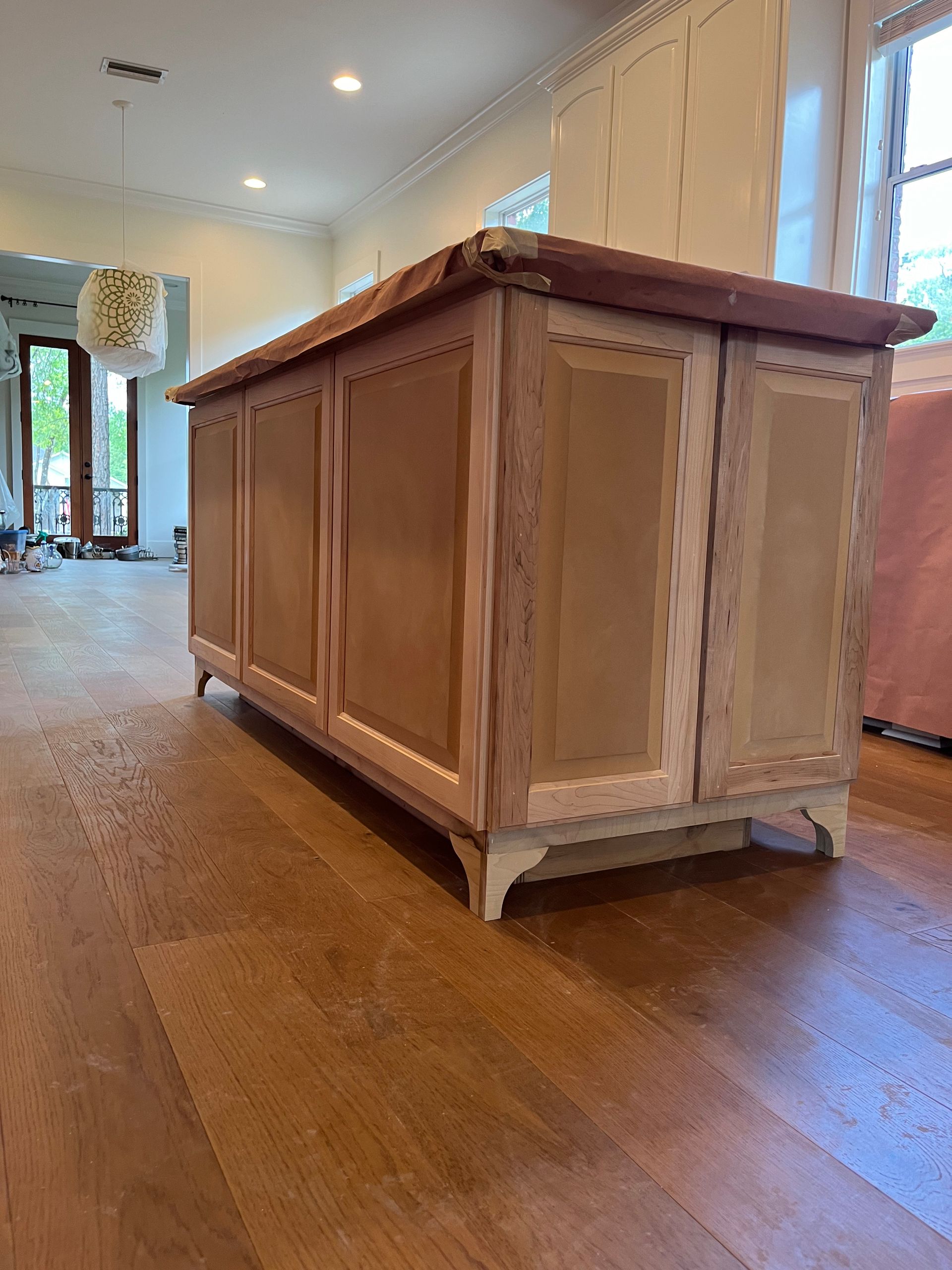 A wooden cabinet is sitting on a wooden floor in a living room.
