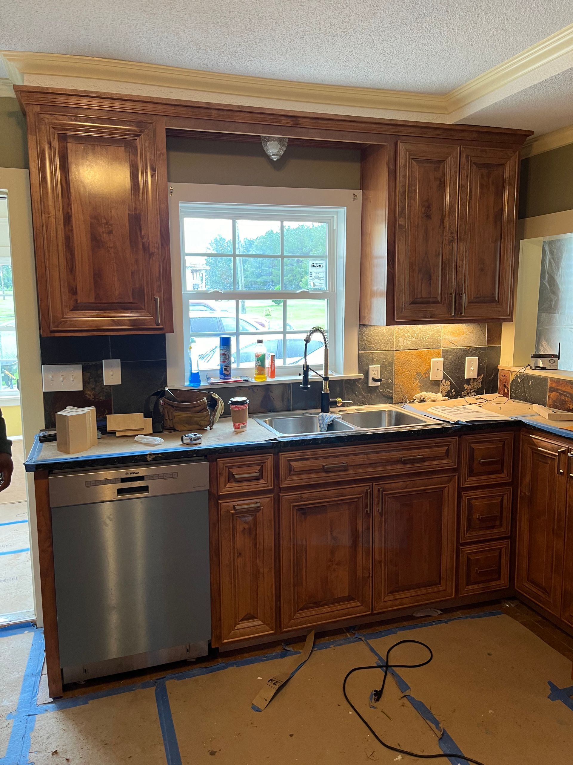 A kitchen with wooden cabinets and a stainless steel dishwasher