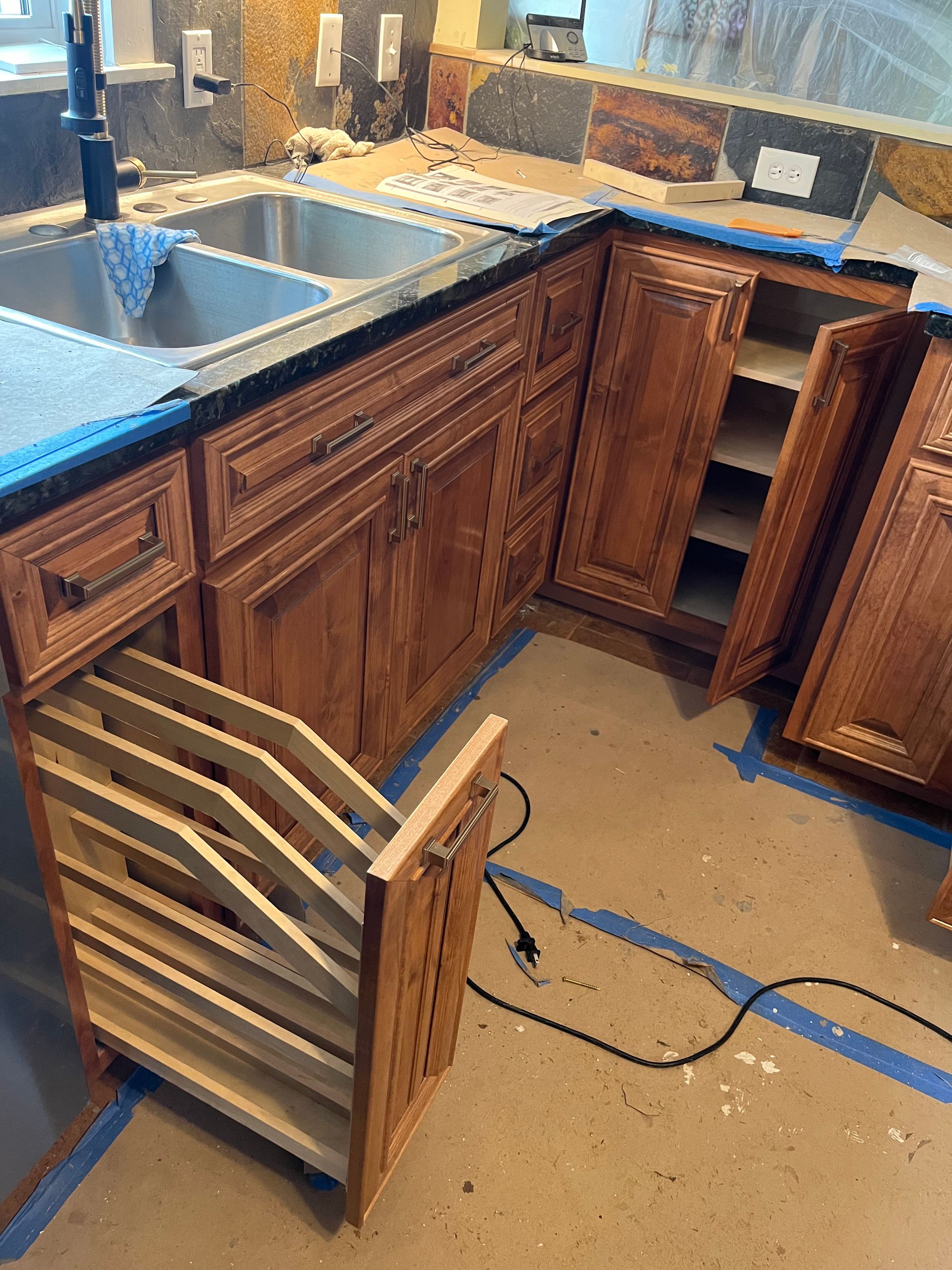 A kitchen with wooden cabinets and a stainless steel sink.